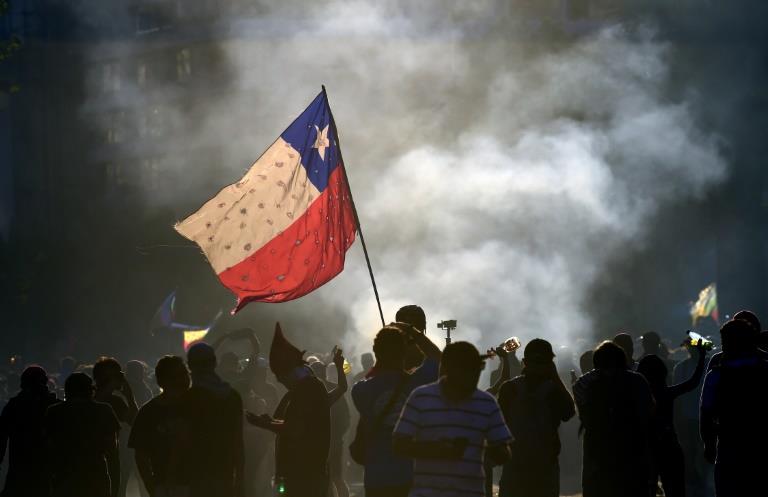 متظاهرون يرفعون علم تشيلي في العاصمة سانتياغو في 2