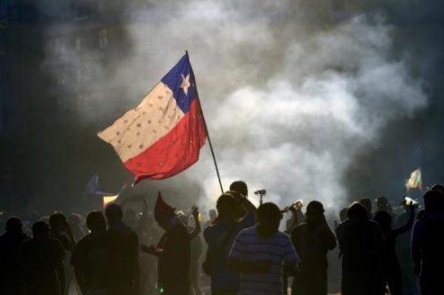 متظاهرون يرفعون علم تشيلي في العاصمة سانتياغو