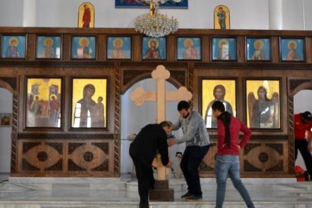 الأب جورج رزق يضع صليبا في كنيسة في درعا بجنوب سور