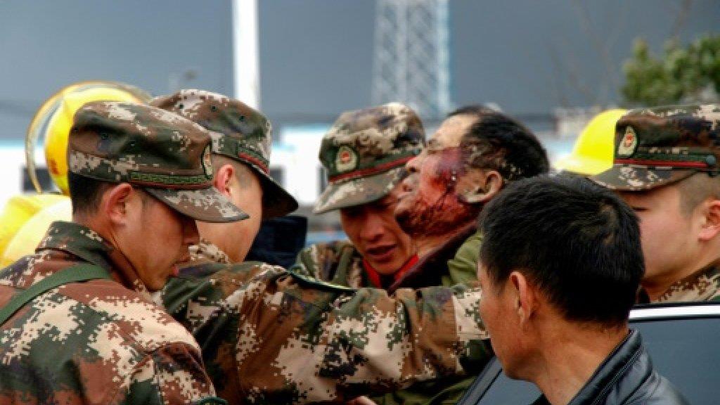 عناصر في قوات شبه عسكرية ينقلون رجلا مصابا في انفج