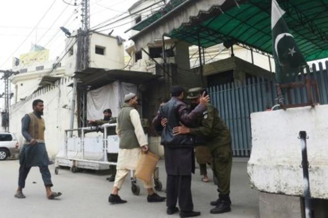 شرطي باكستاني يفتش الواصلين لأداة صلاة الجمعة في م
