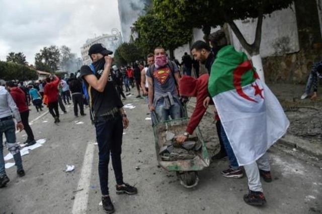 يضع العلم الجزائري فوق كتفيه خلال تظاهرة في العاصم