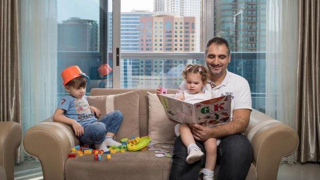 فؤاد كيالي يقرأ لطفليه مازن وجولي في منزلهم في دبي