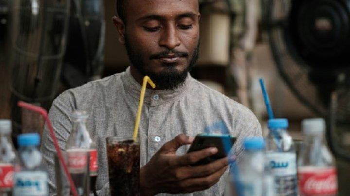الشاب السوداني محمد عمر يتصل بالإنترنت على هاتفه ا