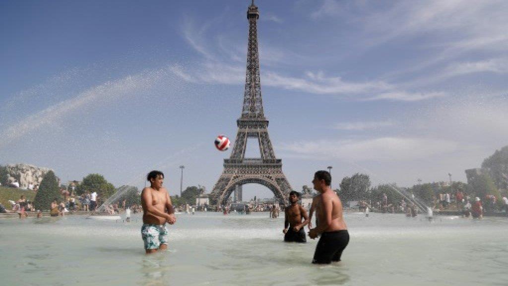 أناس يلهون في المياه مقابل برج ايفل خلال موجة الحر