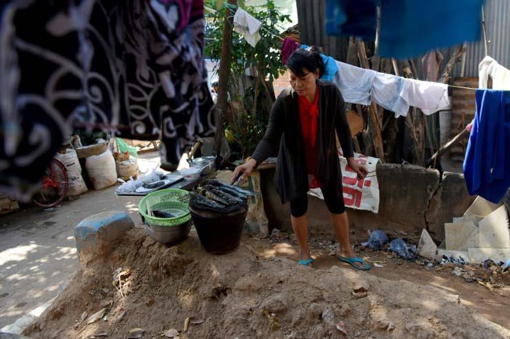 امرأة تشوي السمك على مقبرة في بنوم بنه في 7 أيارما