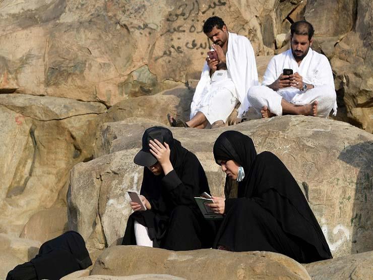 حجاج مسلمون يستخدمون هواتفهم النقالة على جبل عرفات
