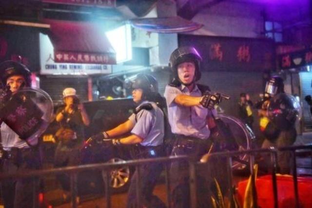 شرطيون يوجهون أسلحتهم الشخصية صوب محتجين في منطقة 