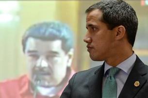 زعيم المعارضة الفنزويلي خوان غوايدو امام صورة للرئ