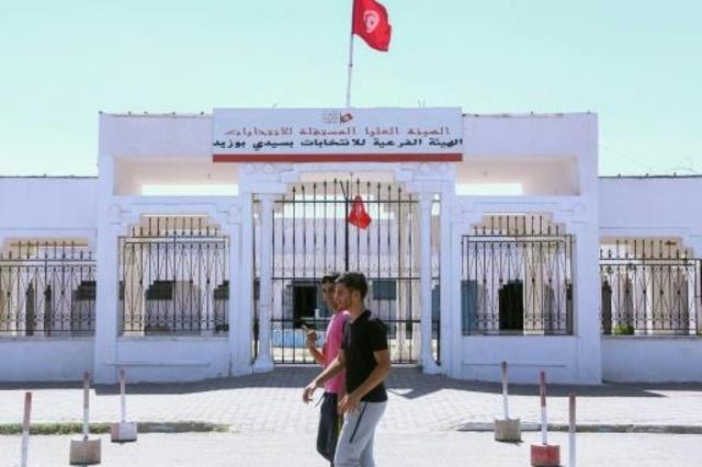 شباب تونسيون يمرون بالقرب من المركز الجهوي للهيئة 