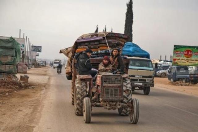 سكان يعبرون مدينة حزانو في شمال محافظة ادلب السوري