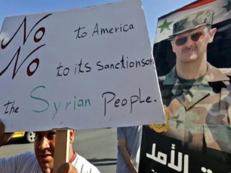 مواطن سوري يرفع لافتة بالانكليزية تتضمن رفضاً للعق