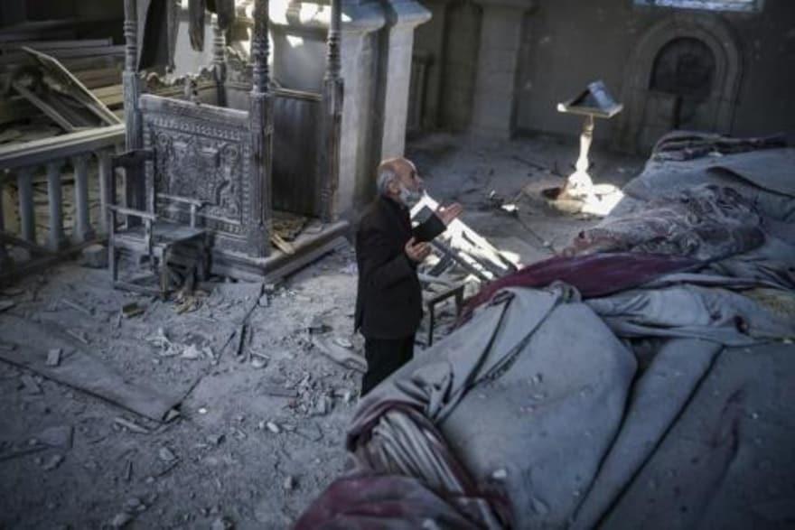 رجل ستيني يصلي داخل كاتدرائية متضررة من القصف في ش