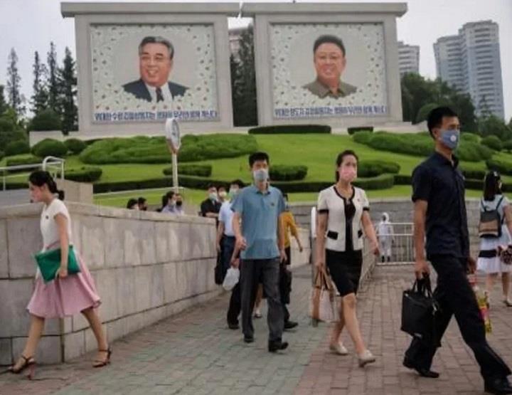  مارة أمام صور الزعيمين الكوريين الشماليين الراحلي