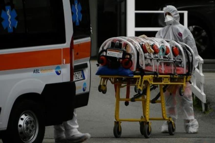 موظفون صحيون يصلون بسيارة إسعاف في نابولي تقل مريض