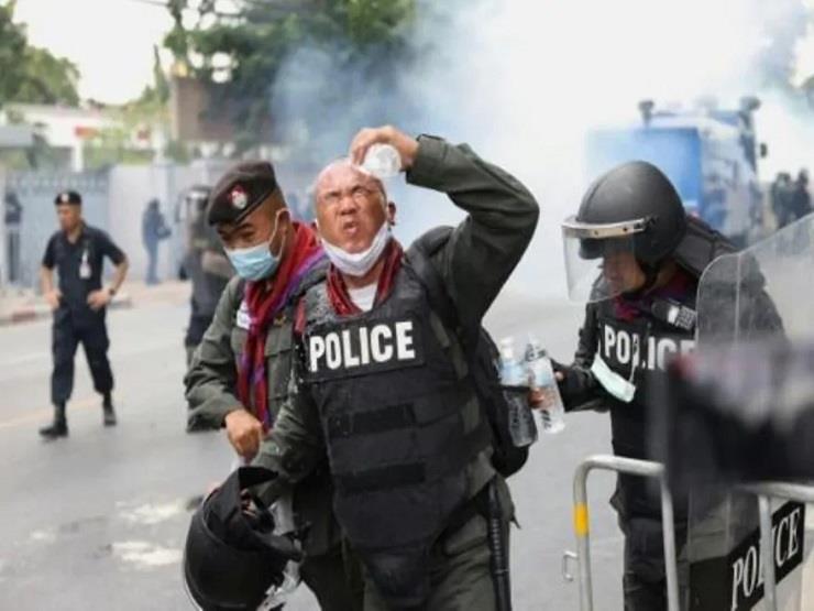 شرطي يغسل عينيه بعد تعرضه لغاز مسيل للدموع خلال تظ