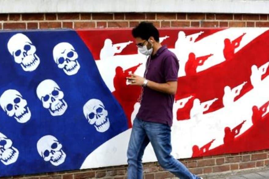   ايراني يمر بالقرب من رسم على جدار السفارة الأمير