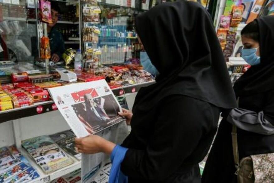 امرأة تنظر إلى الصفحة الأولى لصحيفة ''شرق'' الإيرا