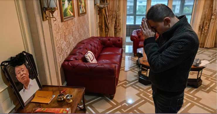 ليو بيين يصلي أمام صورة والده في ووهان في وسط الصي