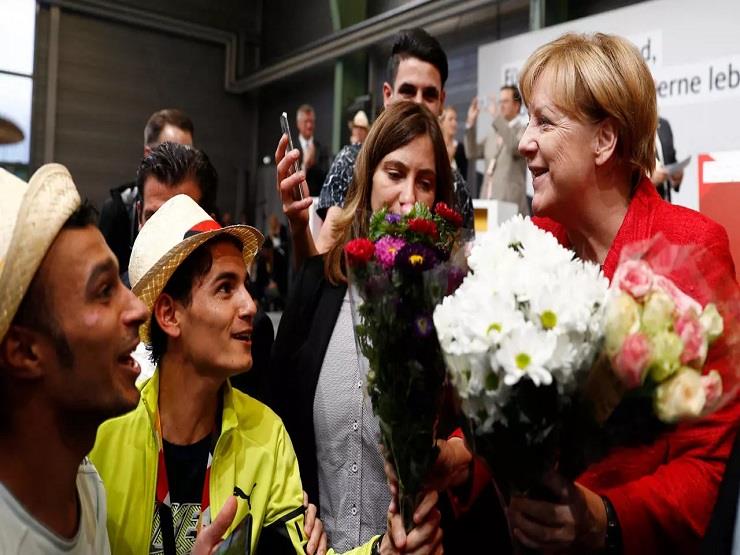 لاجئون سوريون يقدمون الأزهار للمستشارة الألمانية أ