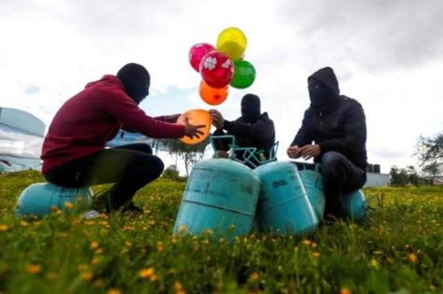 نشطاء فلسطينيون ملثمون يستعدون لإطلاق البالونات ال