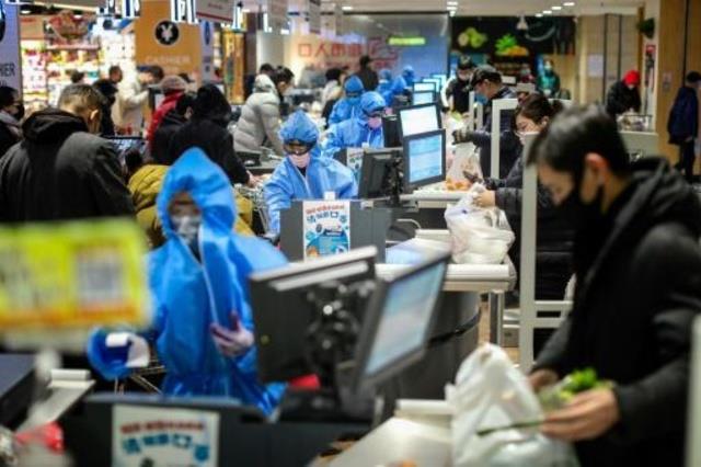 متسوقون في سوق في شنيانغ بشمال شرق الصين يضعون أقن