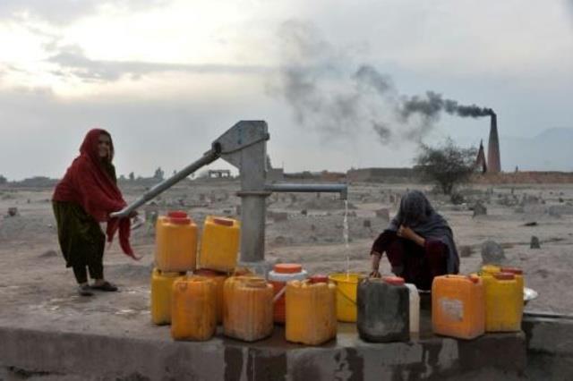 امرأة تملأ مياهاً في ضواحي جلال أباد في أفغانستان