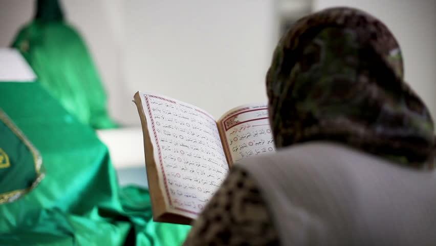 سيدة اثناء تلاوة القرآن الكريم