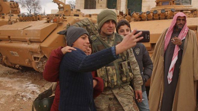 صبية سوريون يلتقطون صورا مع جندي تركي