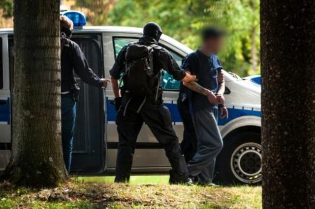 عناصر من الشرطة الألمانية ينقلون مشتبها به لدى وصو