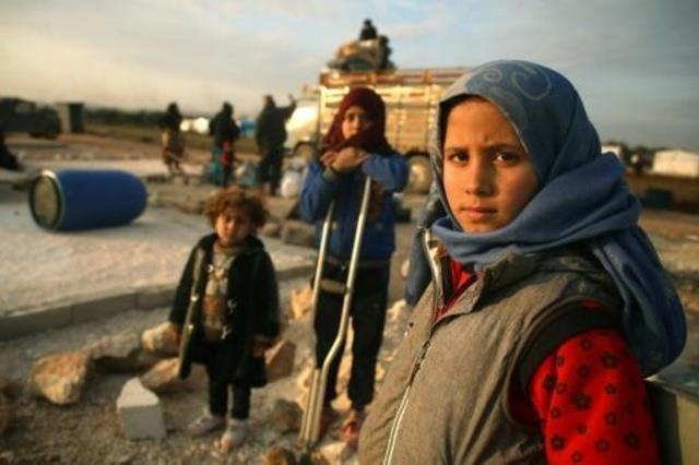 أطفال سوريون ينتظرون في مخيم في شمال غرب سوريا