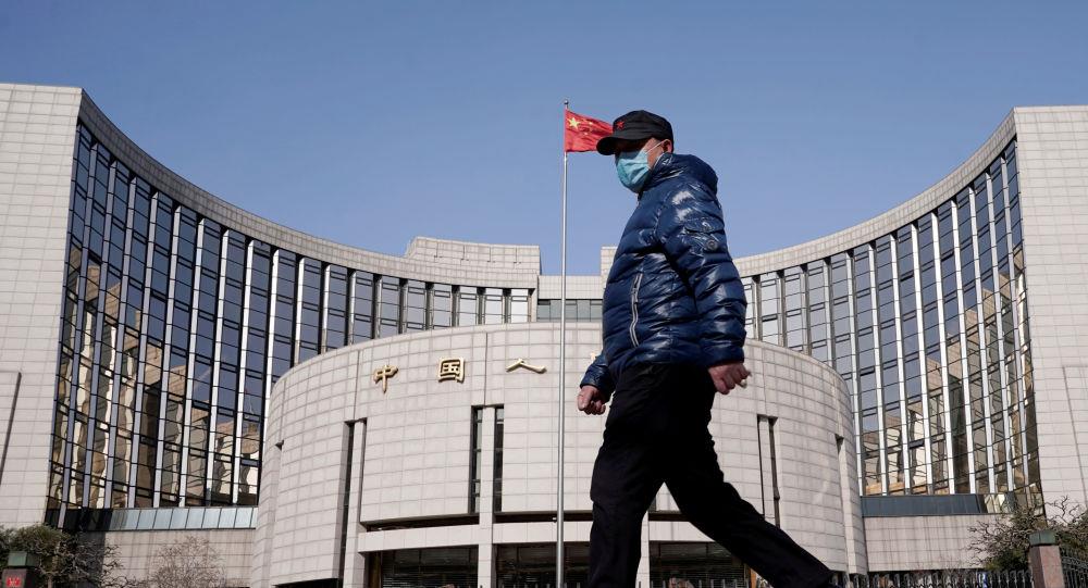 مواطن يمر من أمام البنك المركزي الصيني 