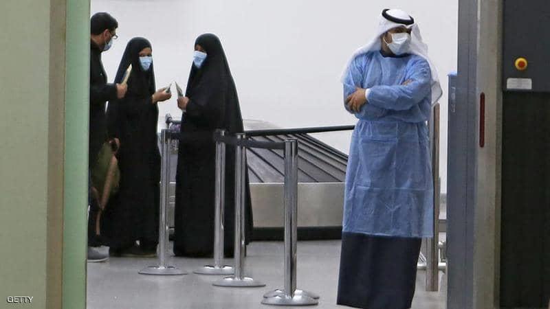 كويتيون عائدون من إيران يرتدون أقنعة واقية في مطار