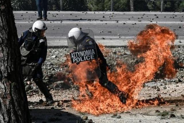 شرطي يوناني يهرب من النيران اثناء مواجهات مع السكا