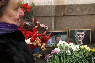 امرأة تضع الزهور في مكان اغتيال بوريس نمتسوف في مو