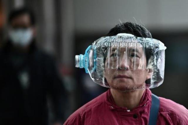 رجل يغطي وجهه بقنينة بلاستيكية كإجراء وقائي من فير