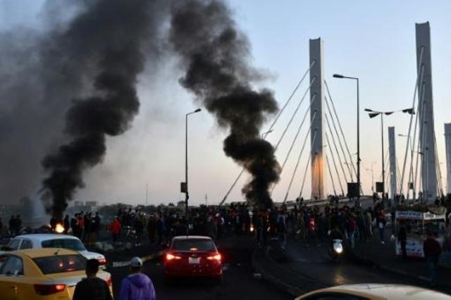 متظاهرون عراقيون يسدون جسراً بالحطام والإطارات الم