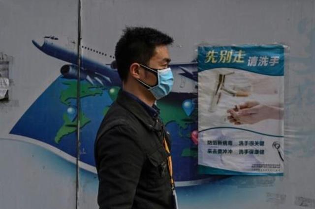 رجل يرتدي قناعاً في أحد شوارع شنغهاي 