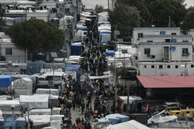 مهاجرون يسيرون في مخيم موريا على جزيرة ليسبوس اليو
