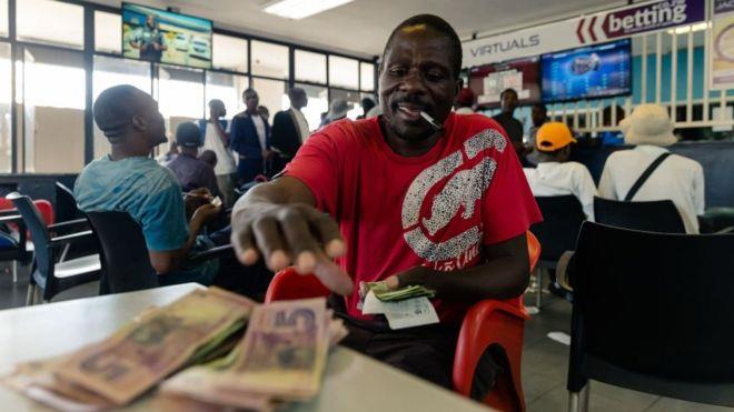 أحد المقامرين في زيمبابوي يحسب بعض مكاسبه على الطا