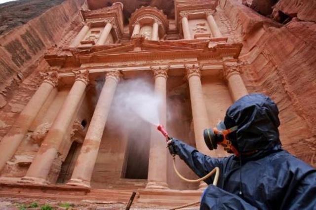 عامل يعقم أحد المواقع الأثرية في البتراء في الأردن