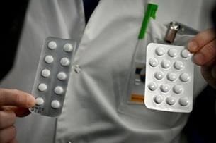 موظف يحمل حبوب دواء كلوروكين في معهد "ميديتيرانيه"