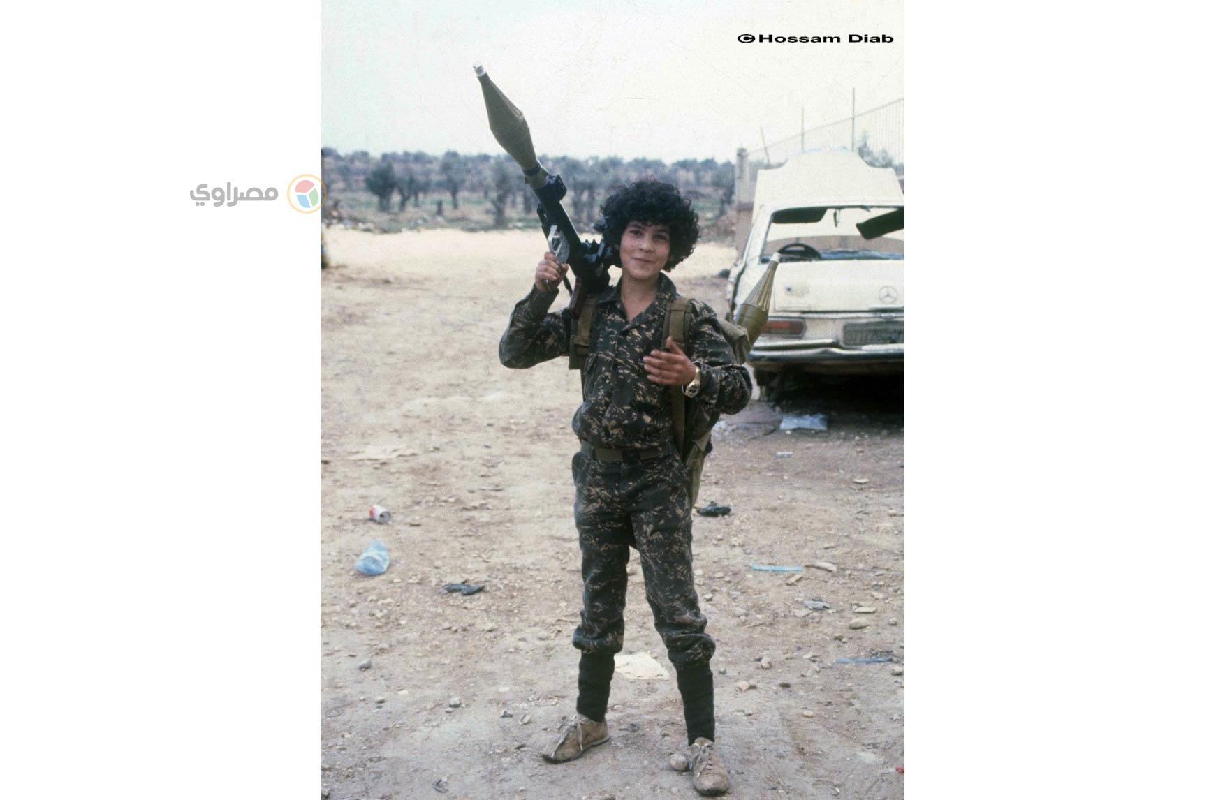 طفل فلسطيني يحمل سلاحًا أكبر منه