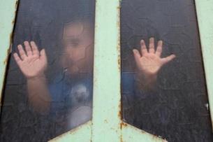 طفل عراقي ينظر إلى الخارج من خلال زجاج نافذة في ظل