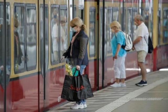 مواطنون يضعون الكمامات في محطة قطارات في برلين في 