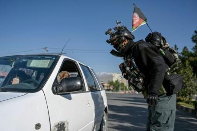 عناصر في الأمن الأفغاني يفحصون سيارة في حاجز أمني