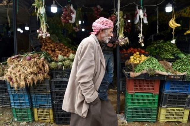 رجل يمر بجانب محل بيع خضار خلال ثاني أيام رمضان في