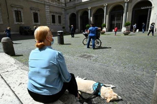 امرأة تتنزه مع كلبها في روما في 3 أيارمايو 2020