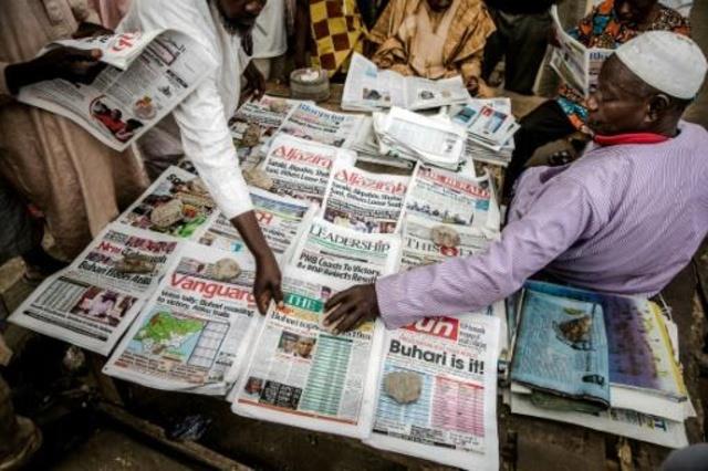 نيجيريان يتحدثان في كشك لبيع الصحف في كانو