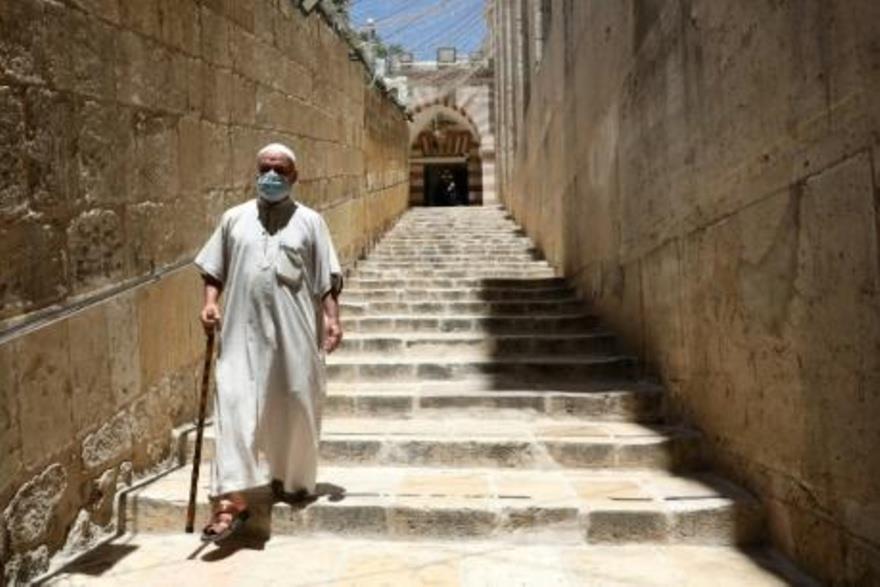 فلسطيني يضع كمامة واقية أثناء مغادرته الحرم الإبرا